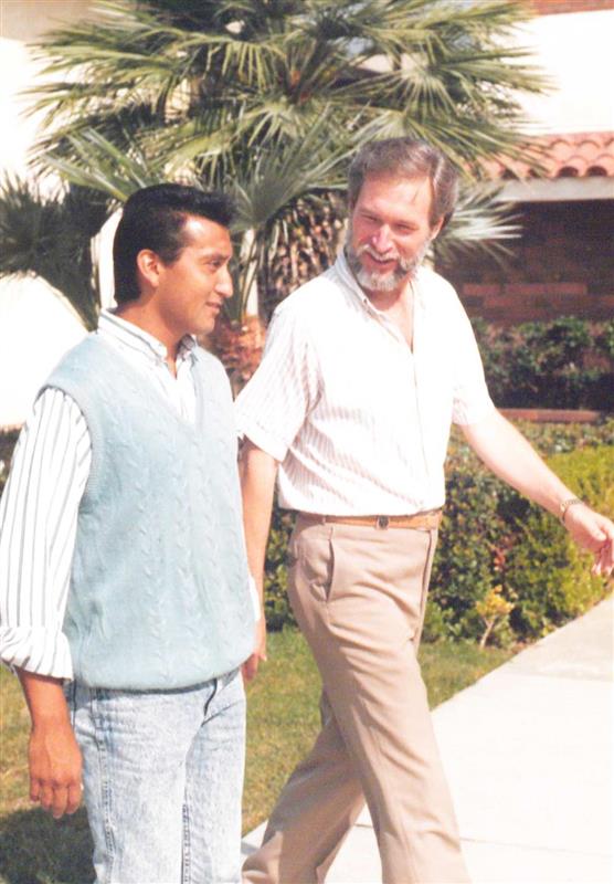 Dr. Murray Dempster walking on the Vanguard campus and talking to another person in the 1990s.