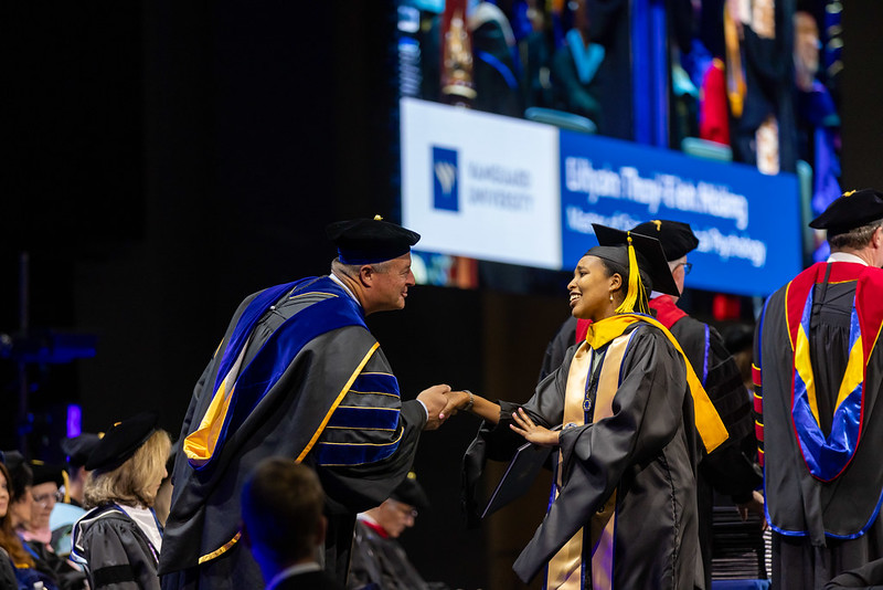 Vanguard student walking across stage at commencement