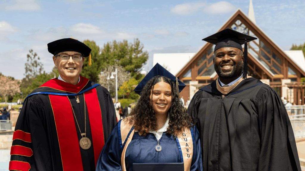 Three people in graduation attire