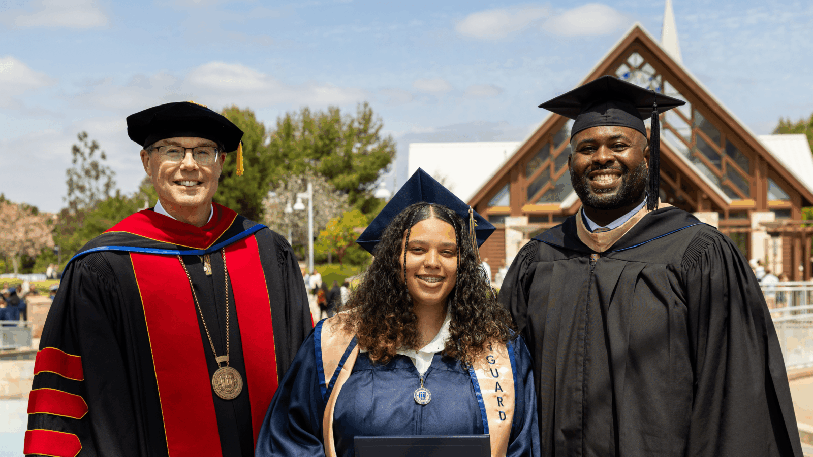 Three people in graduation attire